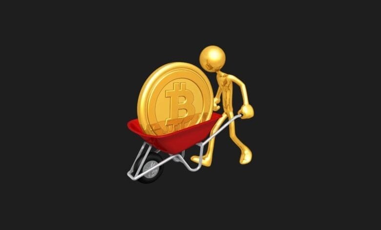 a gold figure pushing a wheelbarrow with a bitcoin coin